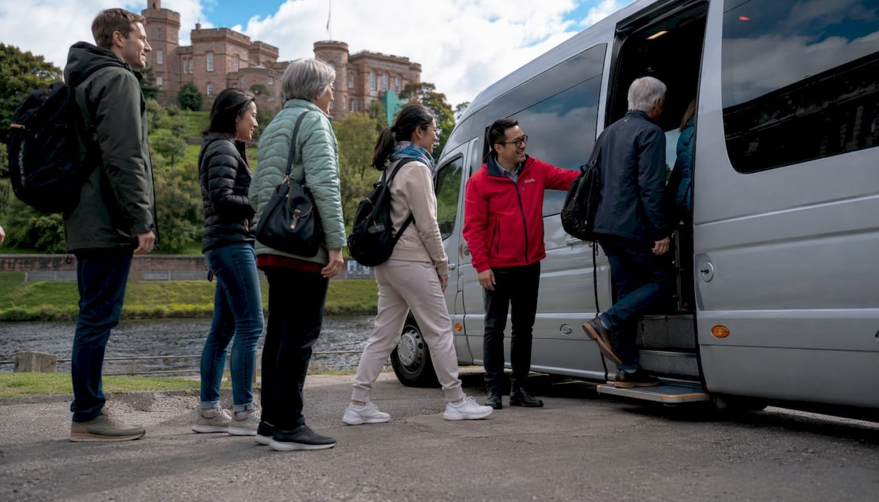 Tourists boarding minibus in Inverness for excursion