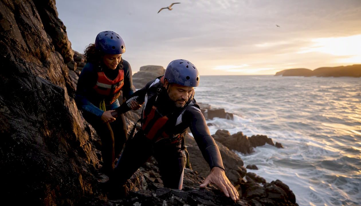Couple coasteering on UK sea cliffs