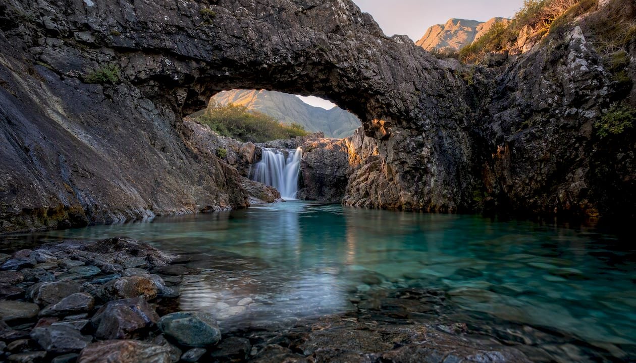 Turquoise pool and rock arch at Fairy Pools