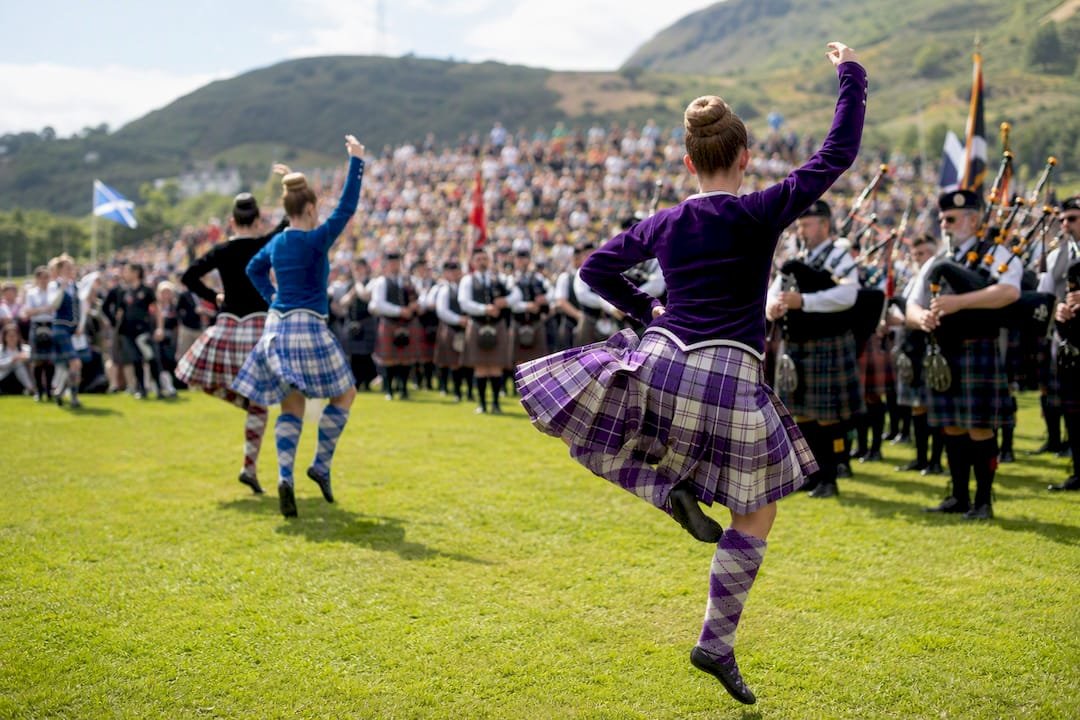 Highland Games pipe band and dancers in competition