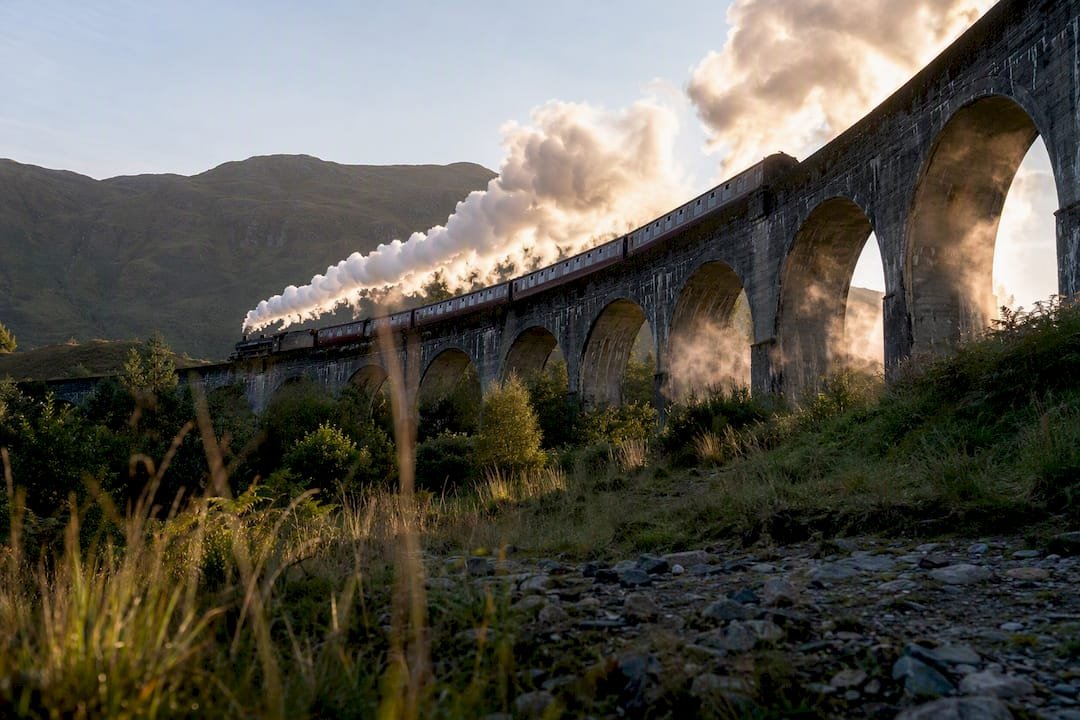 Jacobite steam train steaming under viaduct arches
