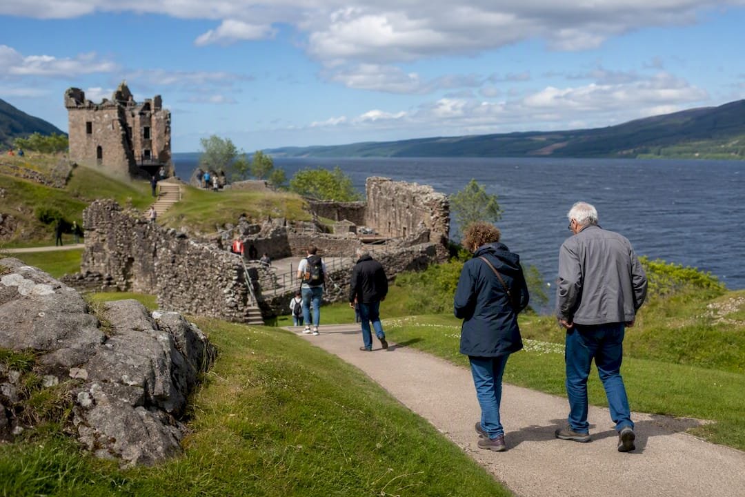 Visitors strolling Urquhart Castle ruins by Loch Ness